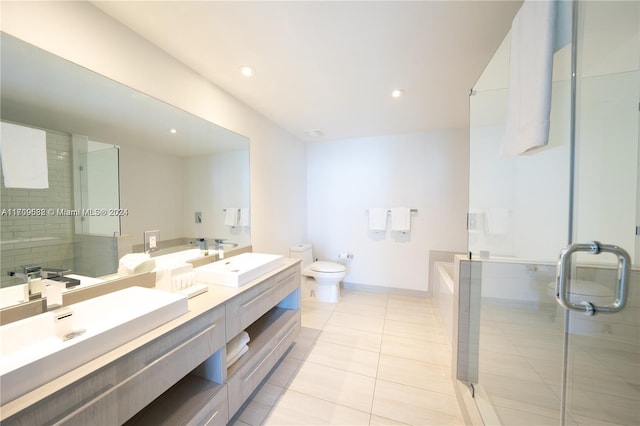 full bathroom with tile patterned floors, vanity, shower with separate bathtub, and toilet