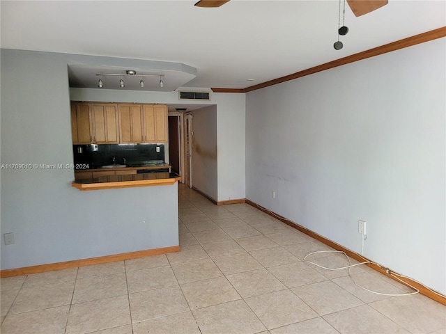 kitchen with sink, backsplash, tile countertops, crown molding, and light tile patterned floors