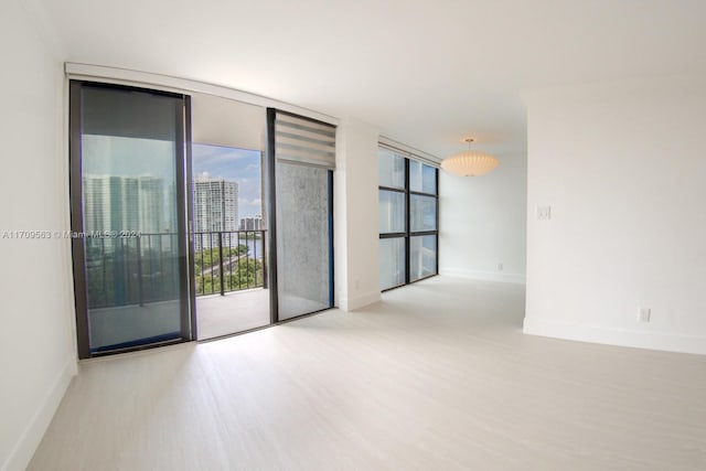 unfurnished room with plenty of natural light, floor to ceiling windows, and light wood-type flooring