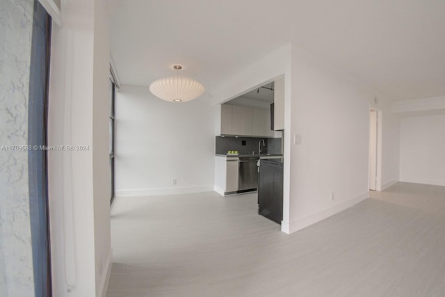 hall with light hardwood / wood-style floors and sink