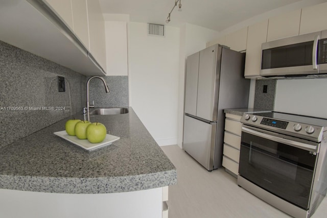 kitchen featuring appliances with stainless steel finishes, backsplash, and sink