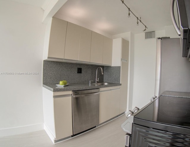 kitchen featuring dishwasher, range, decorative backsplash, and sink