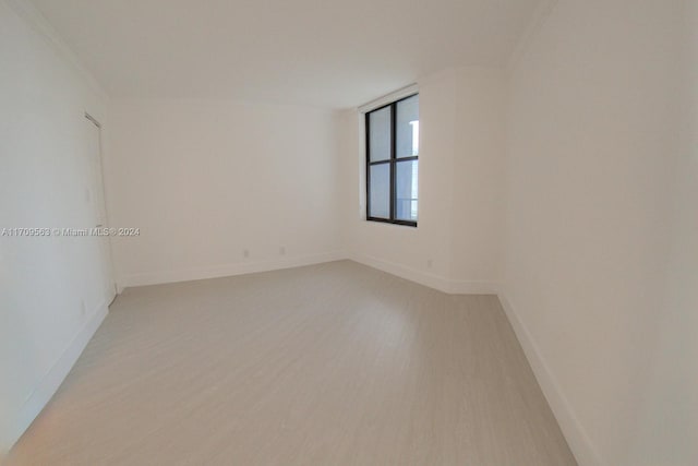 empty room featuring crown molding and light hardwood / wood-style floors