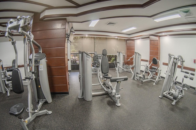 gym featuring crown molding and lofted ceiling