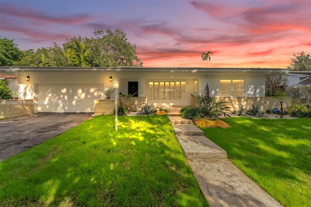 view of front of home with a yard and a garage