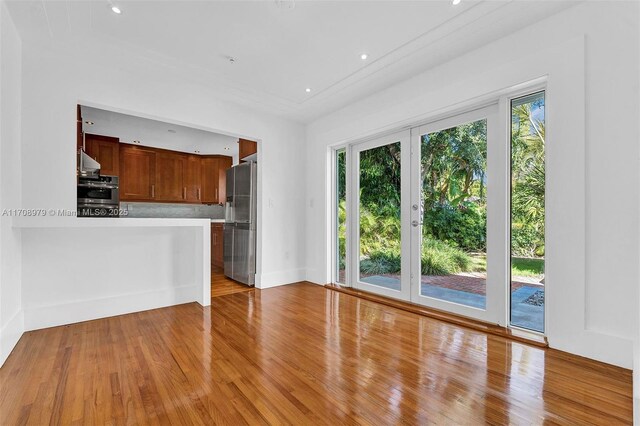 1431 Ancona Ave, Coral Gables, FL 33146 - kitchen with appliances with stainless steel finishes, light wood finished floors, light countertops, a peninsula, and baseboards