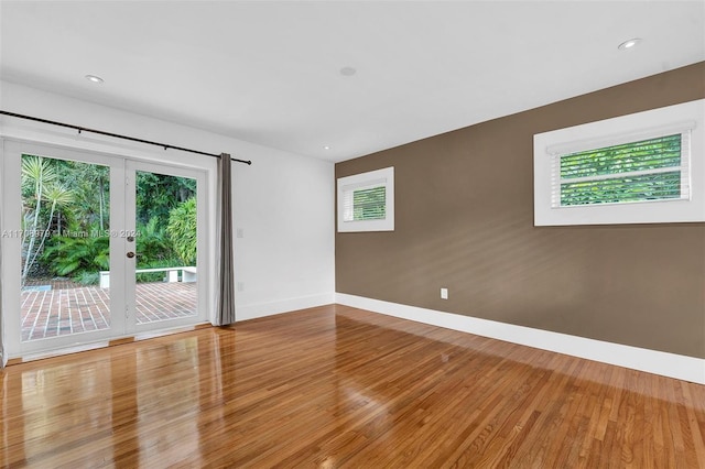 empty room featuring wood-type flooring and a healthy amount of sunlight