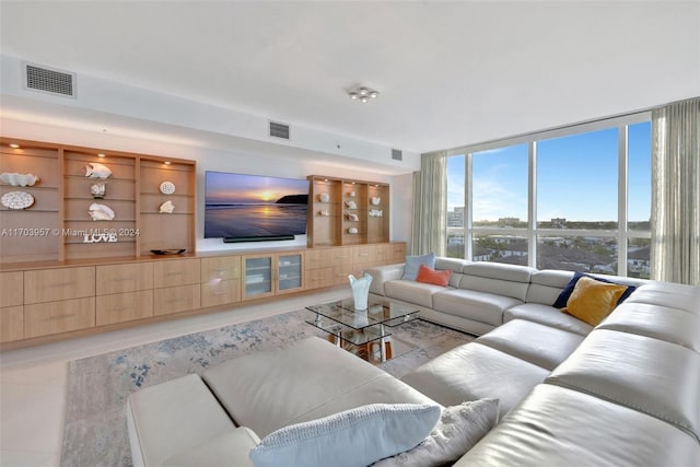 living room featuring expansive windows and light tile patterned floors