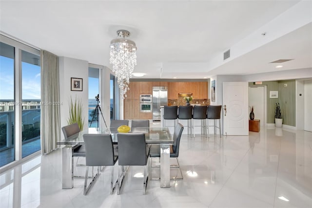 tiled dining space with a chandelier