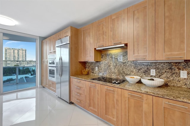 kitchen featuring stainless steel appliances, light stone counters, tasteful backsplash, and light tile patterned flooring