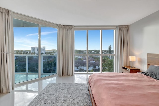 bedroom featuring multiple windows, light tile patterned floors, and floor to ceiling windows