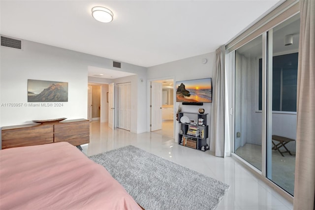 bedroom with light tile patterned floors and connected bathroom