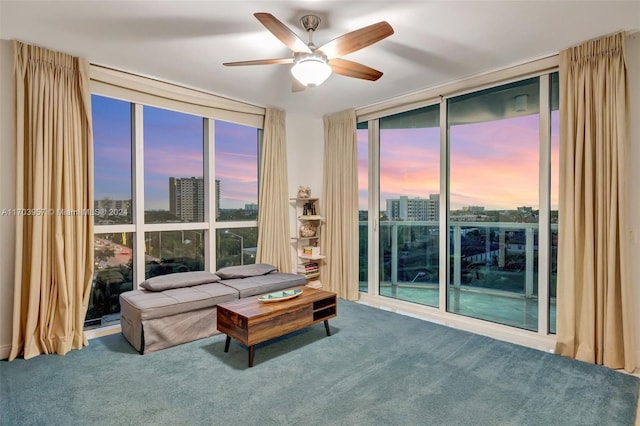 living room featuring carpet floors, expansive windows, and ceiling fan