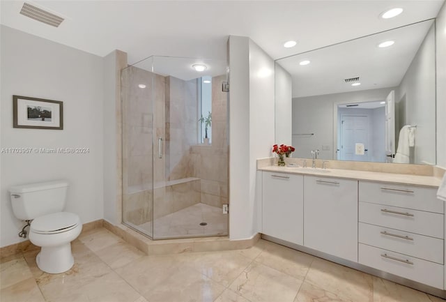 bathroom with vanity, a shower with shower door, and toilet