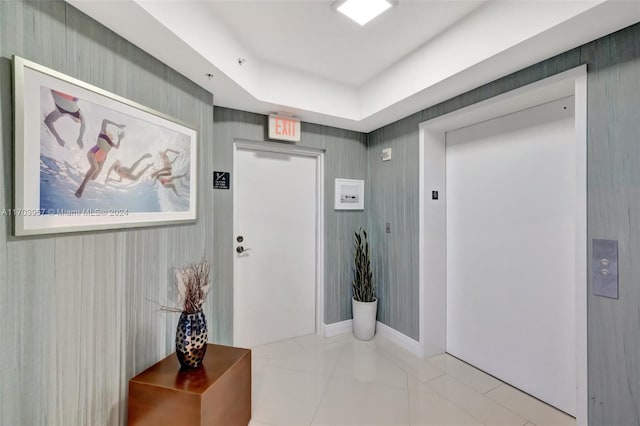 corridor with elevator and light tile patterned flooring