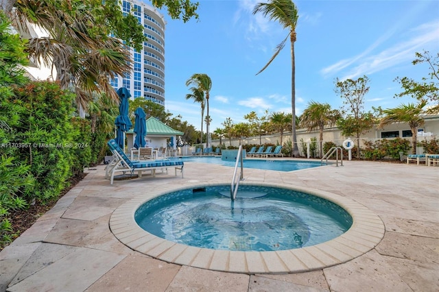 view of swimming pool featuring a patio and a hot tub