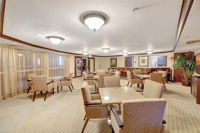 dining room with light colored carpet and crown molding