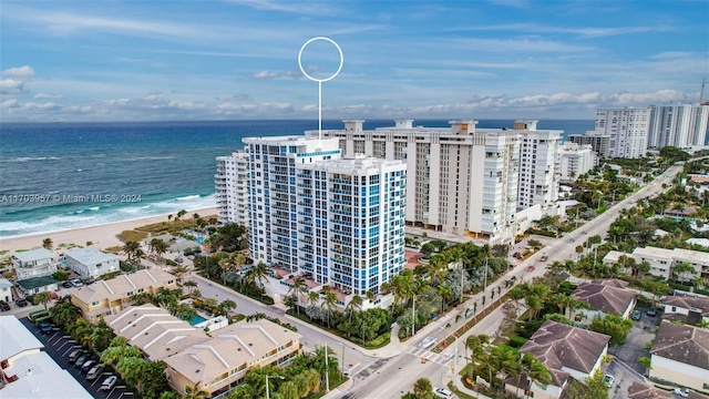 birds eye view of property with a water view and a beach view