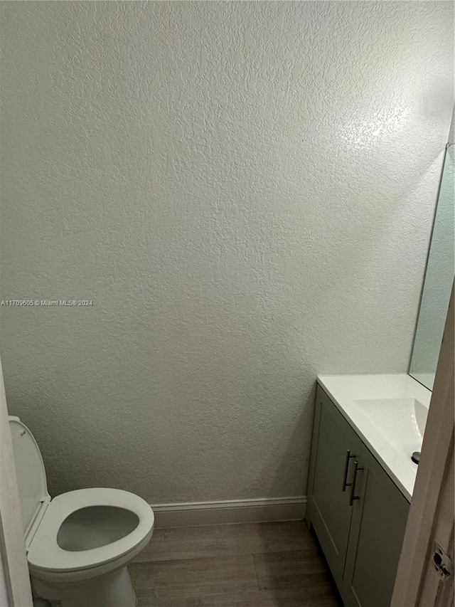 bathroom with vanity, hardwood / wood-style flooring, and toilet