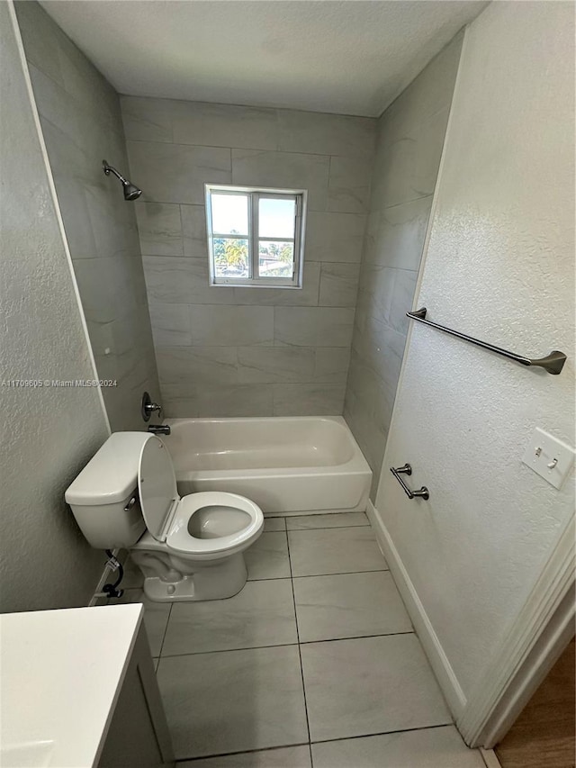 full bathroom featuring tile patterned floors, tiled shower / bath combo, toilet, and vanity