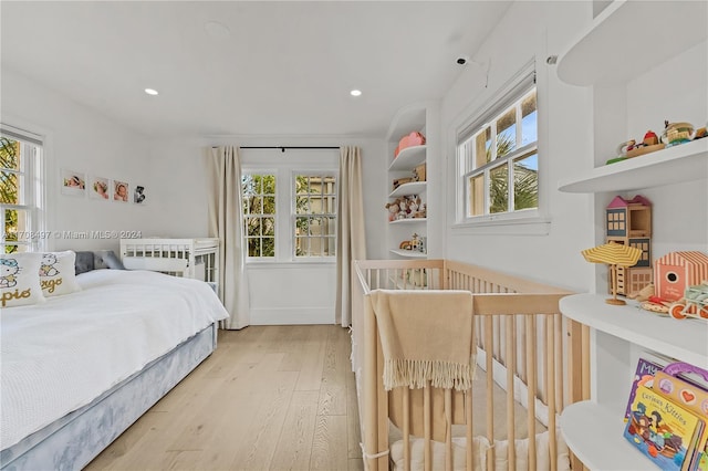 bedroom with multiple windows and light wood-type flooring