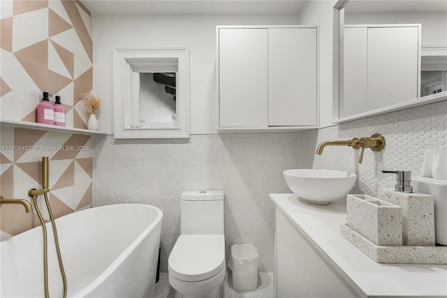 bathroom with a tub to relax in, vanity, and toilet