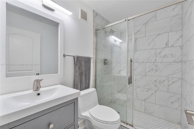 bathroom featuring a shower with door, vanity, and toilet