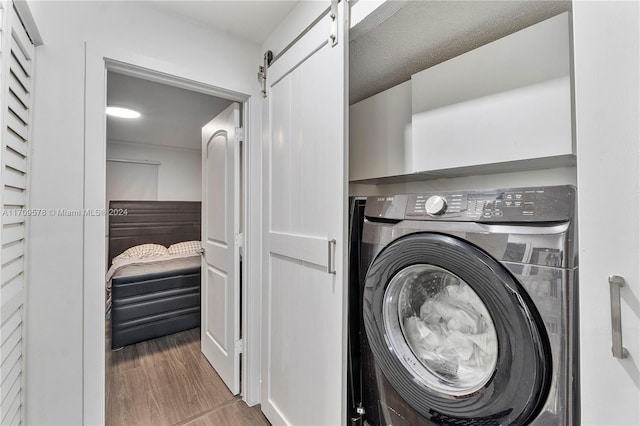 10307 SW 20th St, Miramar, FL 33025 - washroom with washer / clothes dryer, wood finished floors, and a barn door