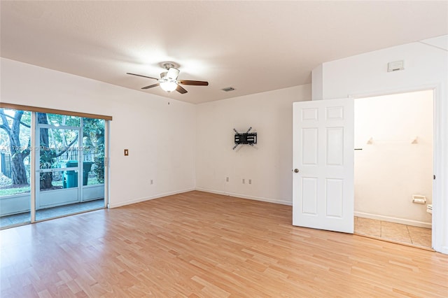 empty room featuring baseboards, a ceiling fan, visible vents, and light wood-type flooring