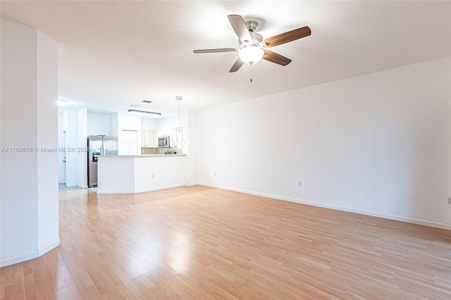 unfurnished living room with light wood-style flooring, baseboards, a textured ceiling, and ceiling fan