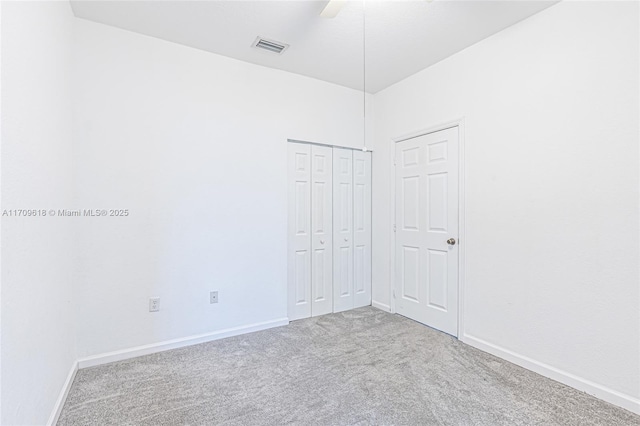 carpeted spare room with visible vents and baseboards