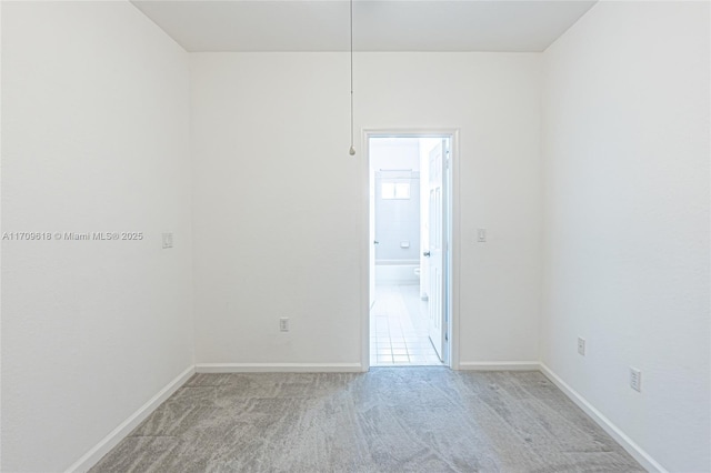 empty room with light colored carpet and baseboards