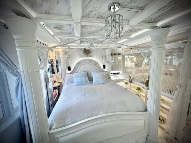 bedroom featuring beam ceiling, decorative columns, coffered ceiling, and a notable chandelier