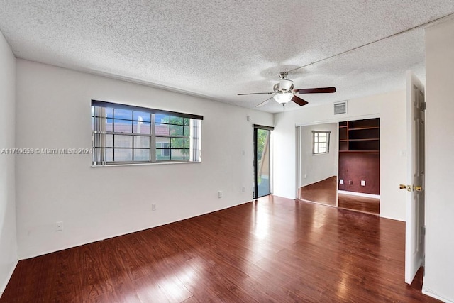 spare room featuring a textured ceiling, ceiling fan, and dark hardwood / wood-style floors