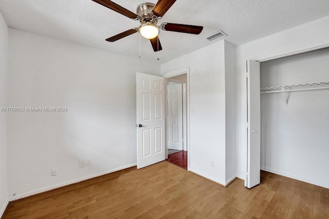 unfurnished bedroom featuring hardwood / wood-style floors, ceiling fan, and a textured ceiling