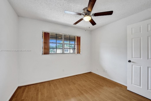 spare room featuring a textured ceiling, hardwood / wood-style flooring, and ceiling fan