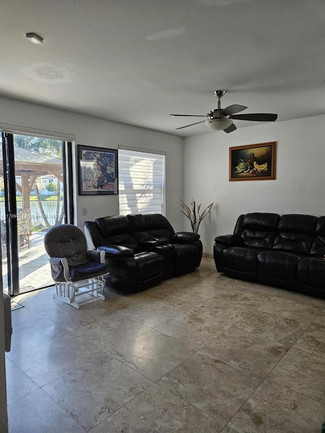 living room with ceiling fan and a healthy amount of sunlight