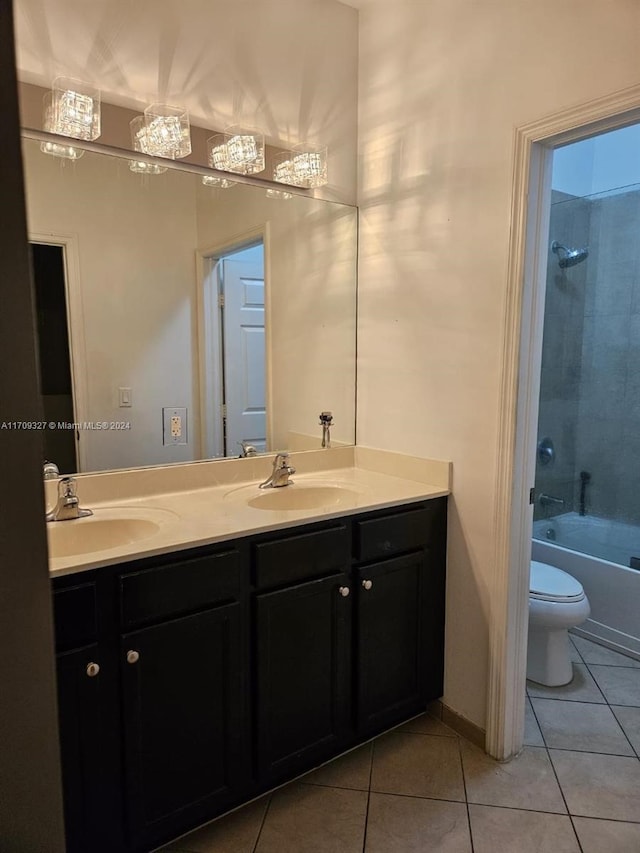 full bathroom with tile patterned floors, vanity, tiled shower / bath combo, and toilet