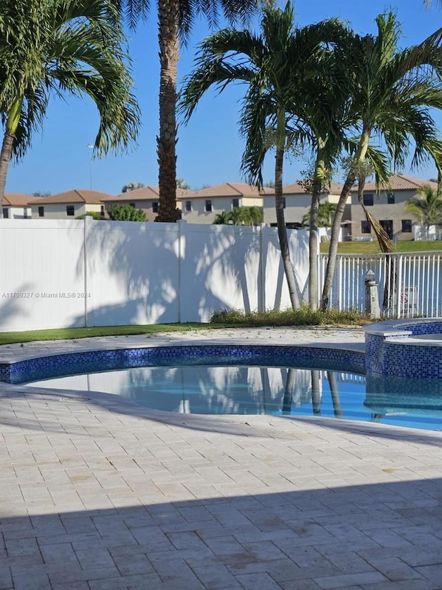 view of swimming pool with an in ground hot tub