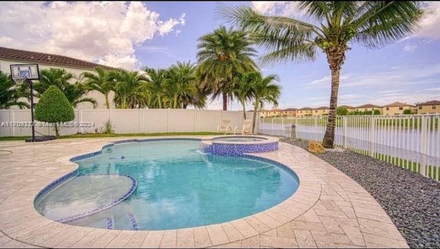 view of pool with an in ground hot tub, a water view, and a patio