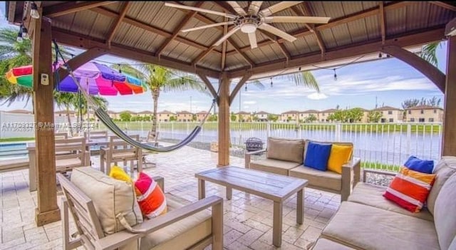 view of patio with a gazebo, an outdoor hangout area, a water view, and ceiling fan