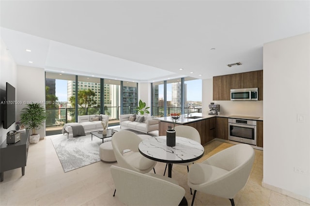 interior space featuring expansive windows, light tile patterned floors, and sink