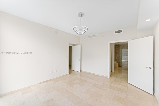 spare room featuring an inviting chandelier