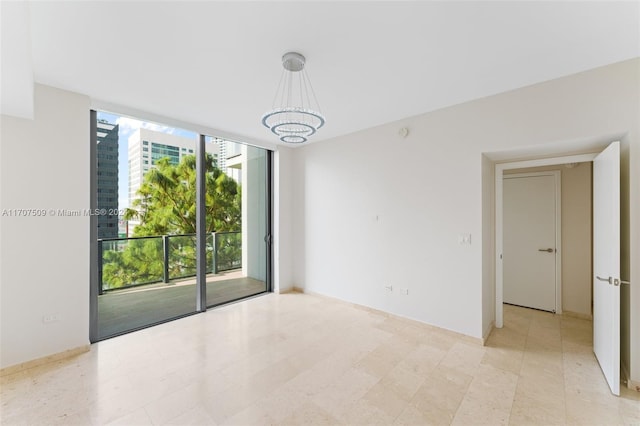 unfurnished room with a notable chandelier