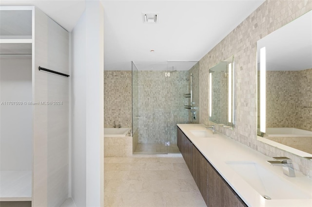 bathroom featuring vanity, tile patterned flooring, plus walk in shower, and tile walls