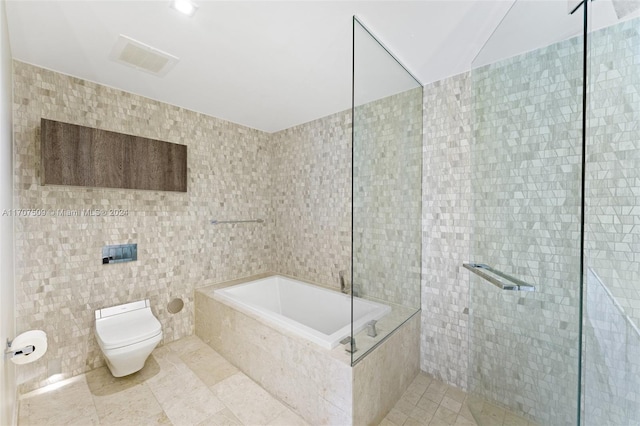 bathroom with toilet, tile patterned floors, and tile walls