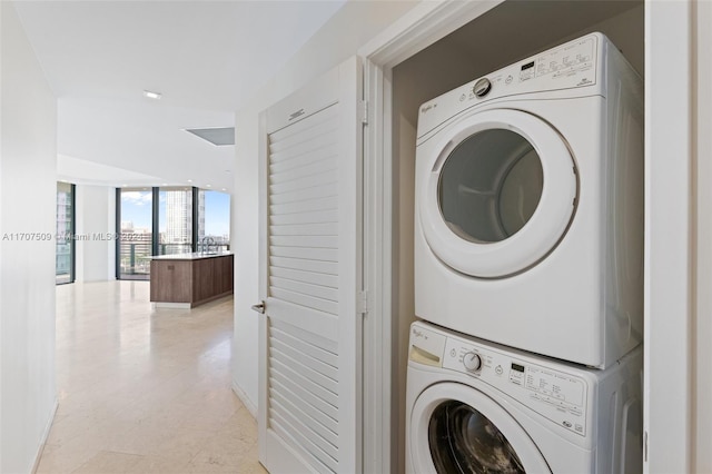 clothes washing area featuring stacked washer and dryer