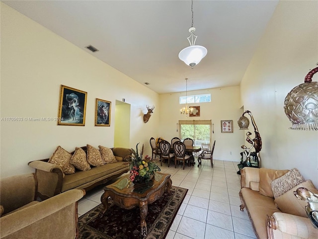 tiled living room with a notable chandelier