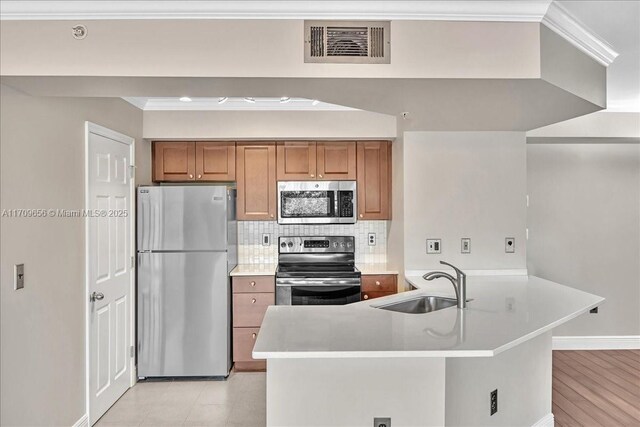 kitchen with decorative backsplash, ornamental molding, stainless steel appliances, sink, and light hardwood / wood-style floors