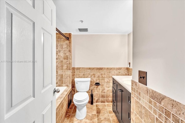 3659 NW Adriatic Ln Unit 305, Jensen Beach, FL 34957 - full bath featuring tile walls, toilet, tiled shower / bath, vanity, and tile patterned floors